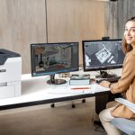 Woman in an office next to the Xerox® VersaLink® C620 printer